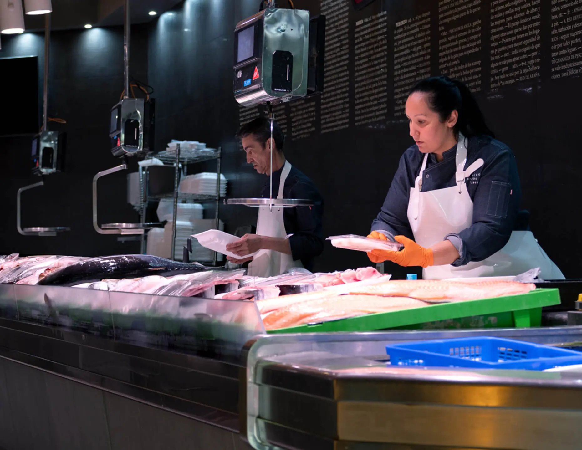 Pescaderos preparando pescado fresco en el mostrador de Pescados Saturnino, en Zaragoza